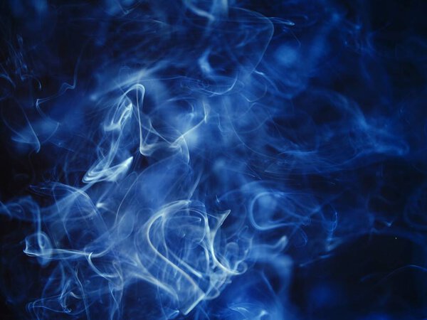 Blue smoke fumes on black background shot selective focus
