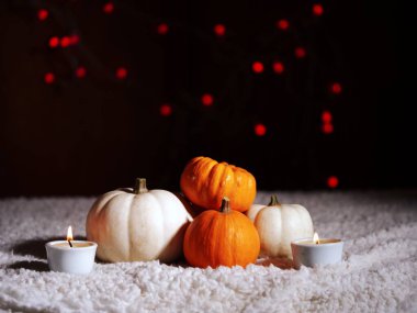 Sıcak arkaplanda mumları olan sonbahar balkabakları seçici odak noktası