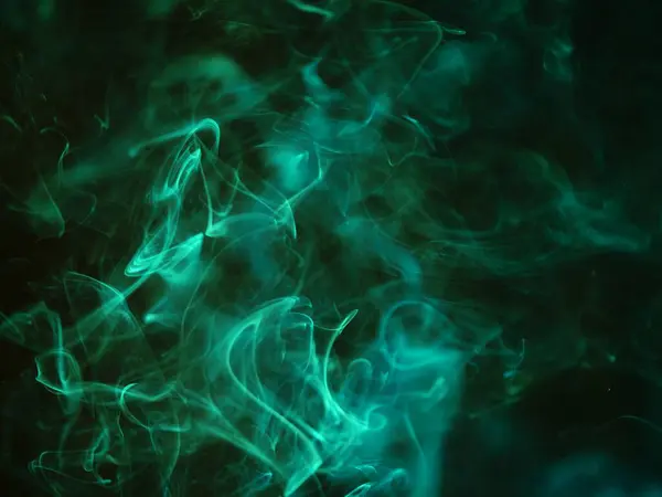 Siyah arkaplanda yeşil duman dumanı seçici odak noktası