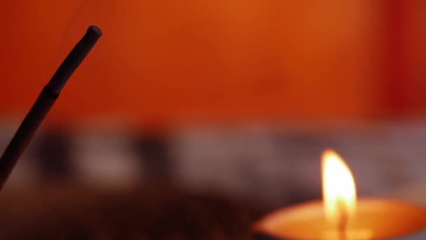 带有蜡烛火焰背景的香棒燃烧慢动作缩放特写选择性焦距 — 图库视频影像