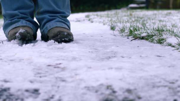 暖かい媒体4Kの遅い動きの選択的な焦点を保つために雪の足を動かして下さい — ストック動画