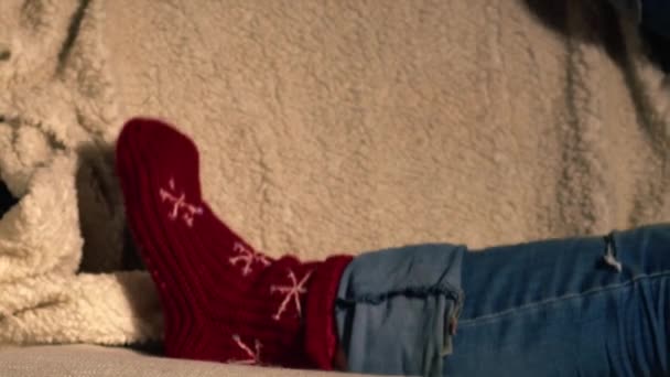 ソファーメディアショットのクリスマスソックスのフィート ズーム遅い動き選択的な焦点 — ストック動画