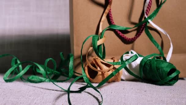 Weihnachtsgeschenktüte Und Bänder Auf Festlichem Bokeh Hintergrund Medium Dolly Slider — Stockvideo