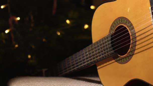 Ακουστική Κιθάρα Μπροστά Από Χριστουγεννιάτικο Δέντρο Μέσο Dolly Πυροβόλησε Επιλεκτική — Αρχείο Βίντεο