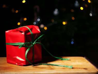 Kırmızı ve yeşil renkli Bokeh arka planına sarılı Noel hediyesi seçici odak noktası 