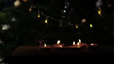 Noel arkaplanında titreyen parlak mumlar. Geniş çekimli seçici odak noktası.