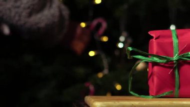 Kırmızı ve yeşil renkli Bokeh arkaplanına sarılı Noel hediyesi. Orta boy seçici odaklanma 