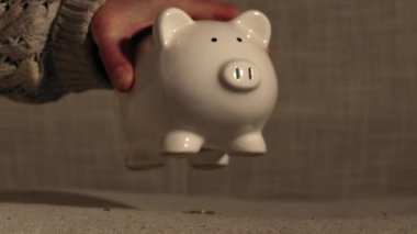 Taking money out of savings piggy bank close up zoom shot selective focus