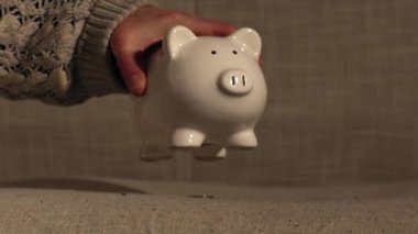 Taking money out of savings piggy bank close up zoom shot selective focus
