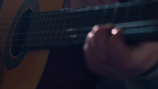 アコースティックギターを演奏するミュージシャンは 4Kショット選択的な焦点を閉じます — ストック動画