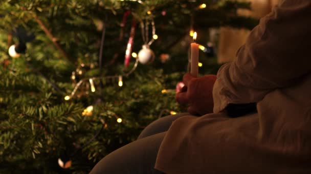 女人坐在圣诞树前 烛光中等4K慢动作选择性聚焦 — 图库视频影像