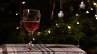 Noel arka planında bir kadeh kırmızı şarap. Orta boy seçici odak noktası.