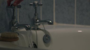 Banyo musluklarını kapatan kadın seçici odak noktasını orta yakınlaştırıyor