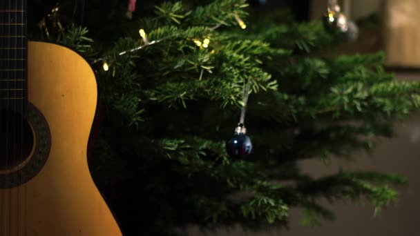 Ακουστική Κιθάρα Μπροστά Από Χριστουγεννιάτικο Δέντρο Μέσο Πυροβόλησε Επιλεκτική Εστίαση — Αρχείο Βίντεο