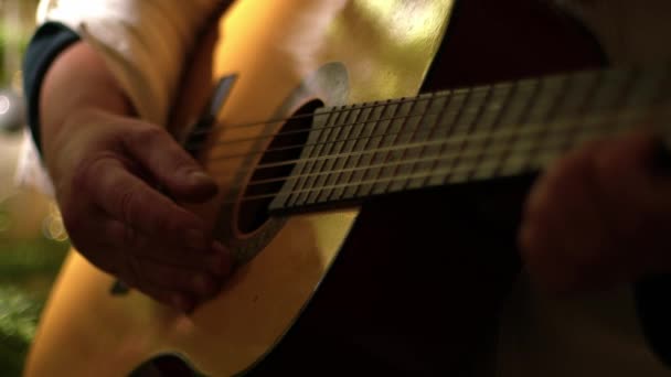 アコースティックギターを演奏するミュージシャン ミディアム4Kショット選択的な焦点 — ストック動画