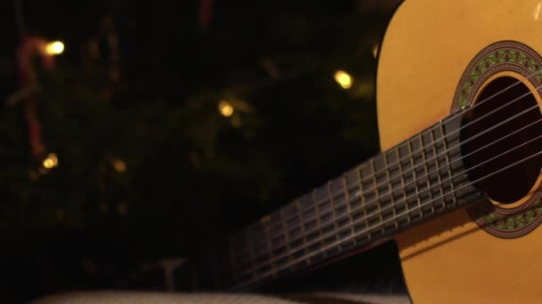 Guitarra Acústica Frente Árvore Natal Zoom Médio Dolly Tiro Foco — Vídeo de Stock