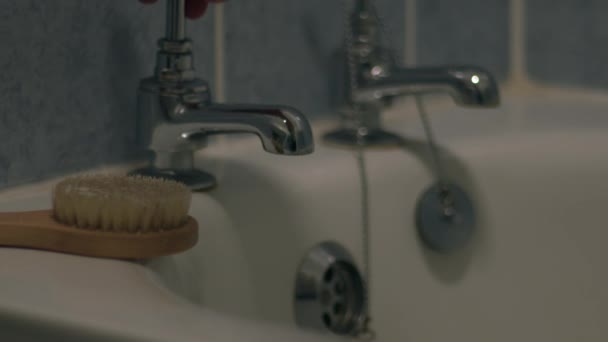 女性は浴槽タップ中4Kショット選択的な焦点を回す — ストック動画