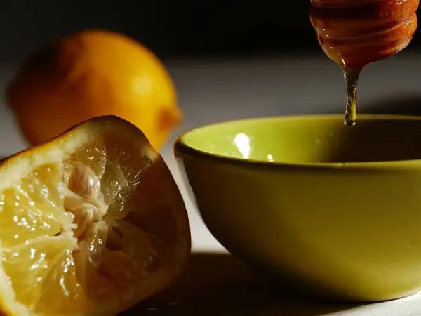 Soğuk algınlığı ve gribin doğal tedavisi için sıcak limon ve bal hazırlıyorum.