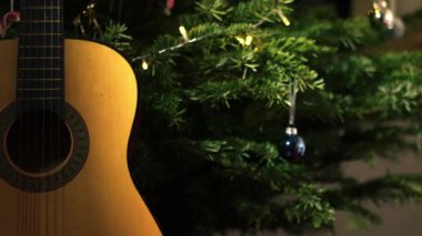 Noel ağacı önündeki akustik gitar seçici odaklanma görüntüsü