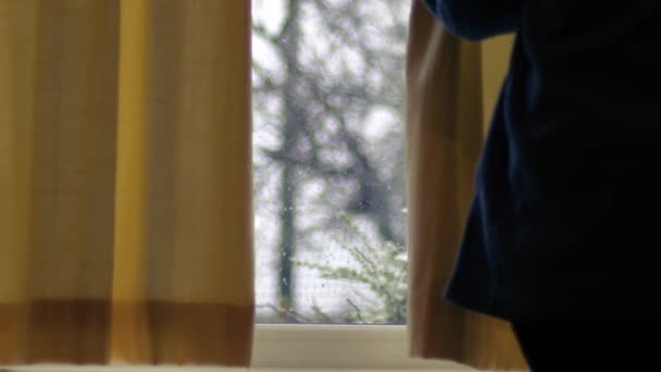 冬季降雪时 妇女拉开窗帘 变焦中镜头选择性聚焦 — 图库视频影像