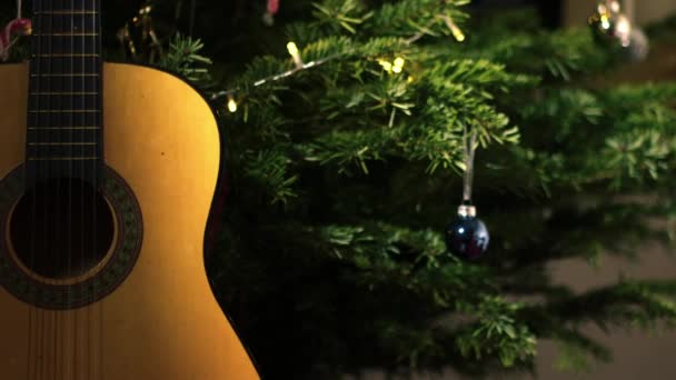 Guitarra Acústica Frente Árvore Natal Zoom Médio Tiro Foco Seletivo — Vídeo de Stock
