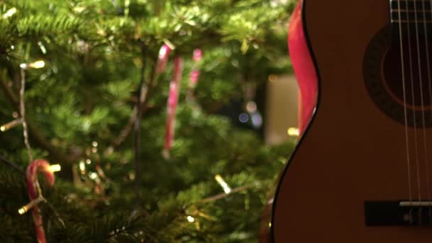 クリスマスツリーミディアムズームショット選択フォーカス前アコースティックギター — ストック動画