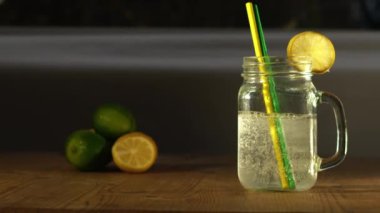 Limon ve limon aromalı köpüklü su bardakta servis edilir. İçme kavanozu.