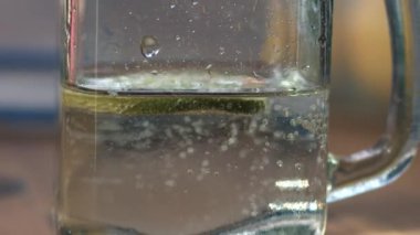 Bardakta servis edilen limonlu gazozlu içecek. İçme kavanozu zoom. Yavaş çekim seçici odak noktası.