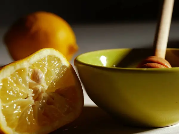 Soğuk algınlığı ve gribin doğal tedavisi için sıcak limon ve bal hazırlıyorum.