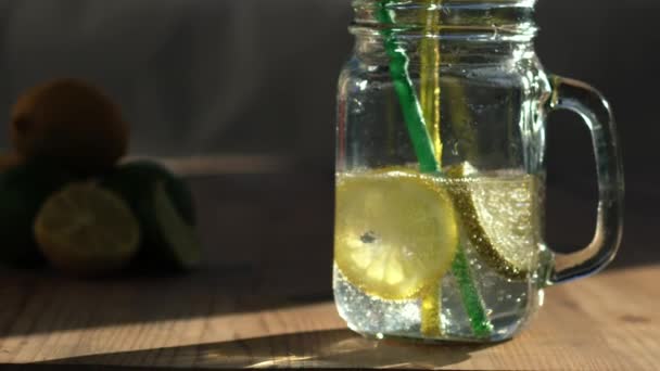 レモンとライム風味の狂った水はガラス飲み瓶で提供され ズームショットスローモーション選択的な焦点を閉じます — ストック動画