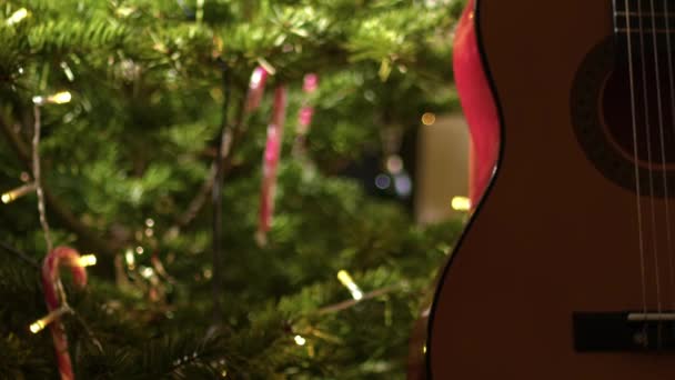 Guitarra Acústica Frente Árbol Navidad Zoom Medio Tiro Enfoque Selectivo — Vídeo de stock