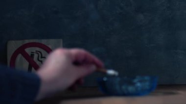 Sigara içilmez tabelasının önünde sigara içmek 4k 'lık seçici odak noktasını kapat