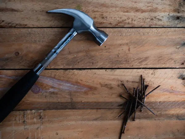 Ahşap arka planda paslı eski çiviler.