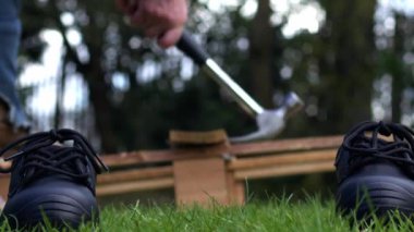 Geri dönüşümlü ahşap sanayi paleti ve çekiç arkaplanlı iş botları seçici odak noktası