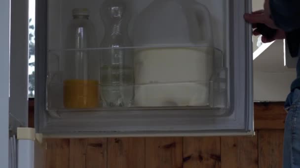 女性は冷蔵庫の中型ズームショット選択的な焦点から新鮮なオレンジジュースを得る — ストック動画