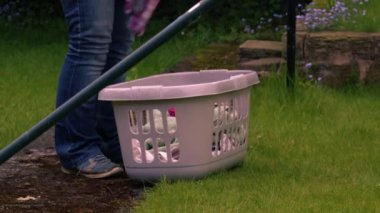 Çamaşırları sepete koyan kadın. Orta boy. Yavaş çekim seçici odak noktası.