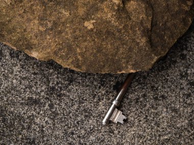 Evin dışındaki kayanın altındaki kapının anahtarı. Yakın çekim seçici odak noktası.