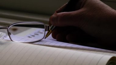 Not defterinde el yapımı notlar okunuyor. Orta yavaş çekimde seçici odaklanma.