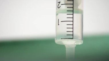 Şırıngada sıvı çözeltisi. Makro 4k yakın çekim. Yavaş çekim seçici odak noktası.