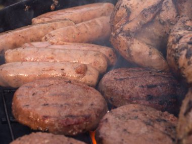 Kömür mangalında pişen sığır burger ve sosisler seçici odaklı orta boy.