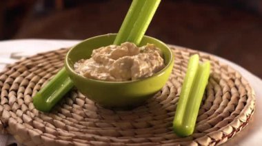 Kerevizi humus kasesine daldırıyorum. Yakın çekim seçici odaklanma.