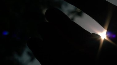 Gün batımında parmaklar arasından gün ışığına çıkar 4k 'lık seçici odak noktasını kapat