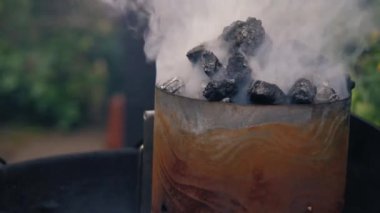 Barbeküde kömür ve kömür dumanı seçici odak noktasında.