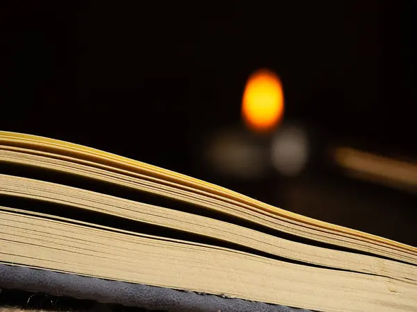 Mum ışığı bokeh arkaplanlı kitabı aç. Görüntüyü kapat seçici odak noktası