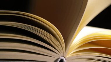 Sayfalar, mum ışığı arkaplanı olan açık bir kitap açar. 4k 'lık seçici odak noktasını kapat