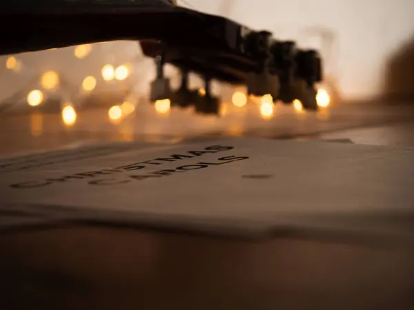 Noel ışıklarının önündeki akustik gitar seçici odak noktası.