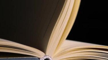 Sayfalar mum ışığı arkaplanı bokeh olan açık bir kitap açar yakınlaştırma çekimini seçici bir odak ile kapatır