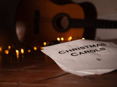 Acoustic guitar in front of Christmas lights medium shot selective focus clipart