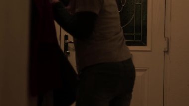 Kadın evin ön kapısından çıkıyor. 4K orta boy, seçici odaklanma.