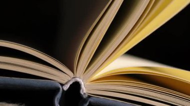 Sayfalar mum ışığı arkaplanı bokeh olan açık bir kitap açar yakınlaştırma çekimini seçici bir odak ile kapatır